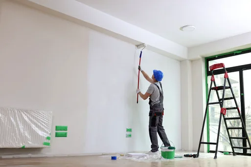 Painter rolling bright white walls to get a Manhattan Beach home ready to list